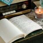 Pierwsza serwetka na szydełku: prosty wzór, który wygląda efektownie Stare radio, zapalona świeca i notes na stole w przytulnym wnętrzu