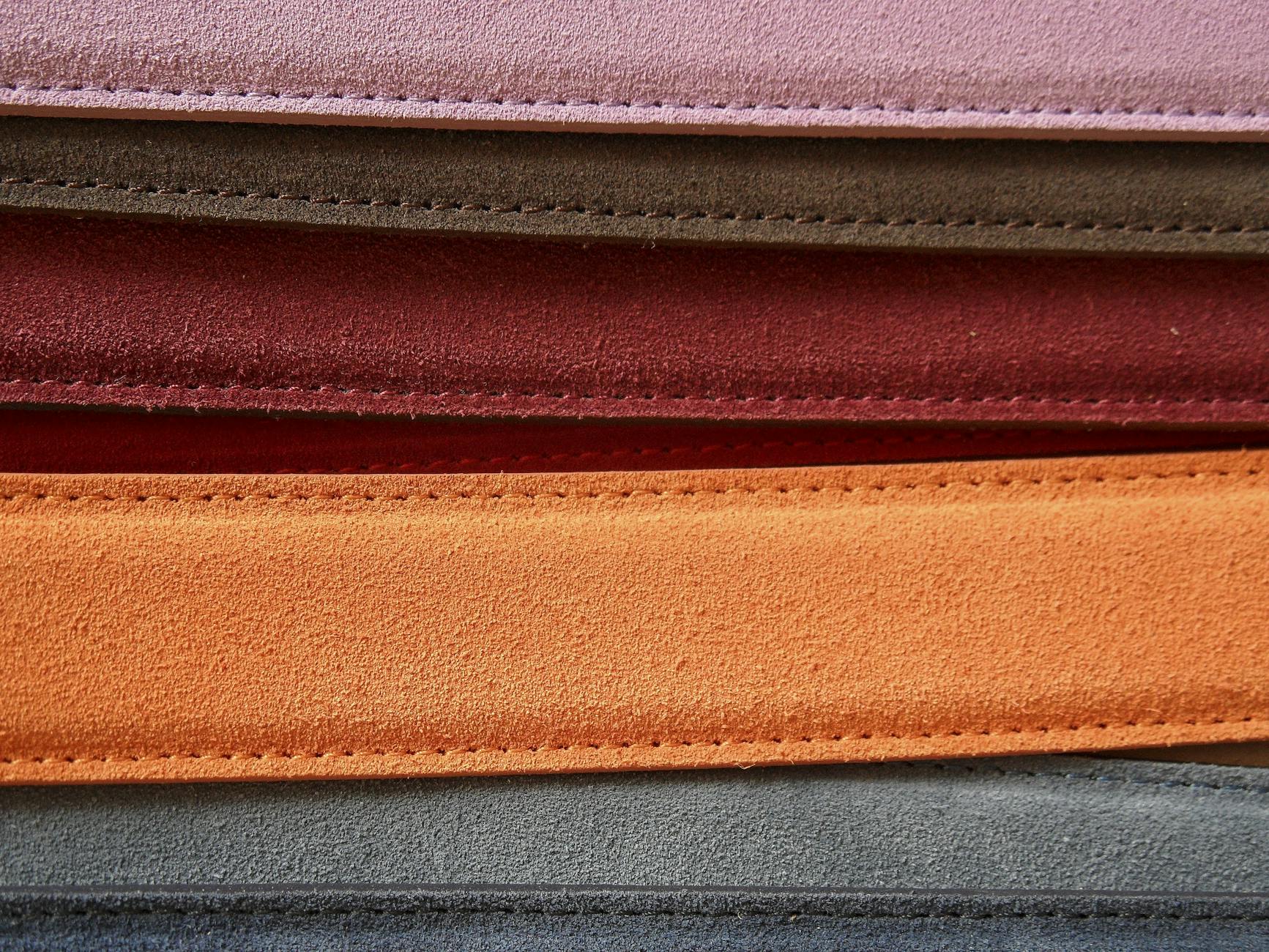 Pasek do spodni z tkaniny: jak zrobić dziurki i estetyczne wykończenie końcówki Zbliżenie kolorowych skórzanych pasków z widocznym ozdobnym stebnowaniem